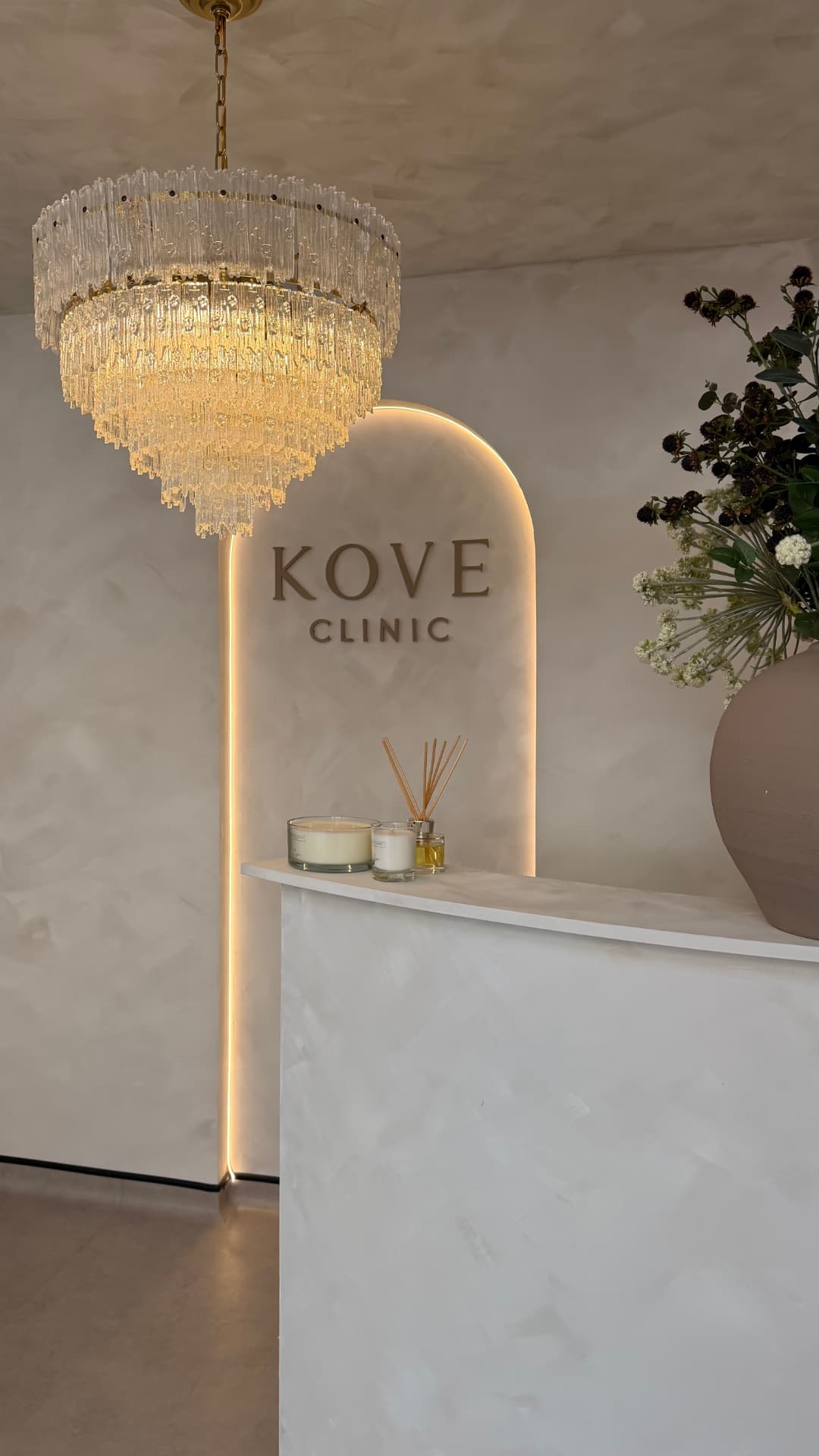 Reception desk under a chandelier at Kove Clinic, Glasgow — home of The J. Edit facial aesthetics